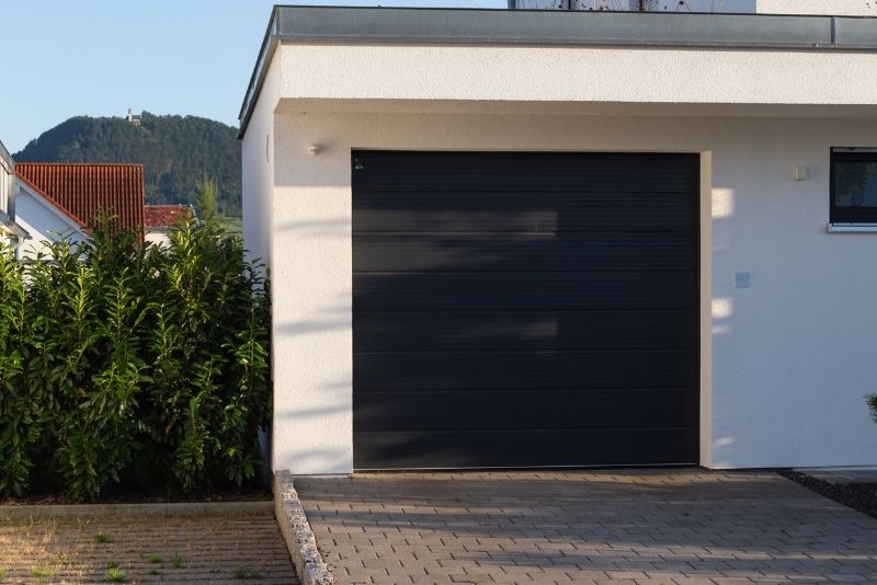 an enclosed carport attached to the house and also has a black gate