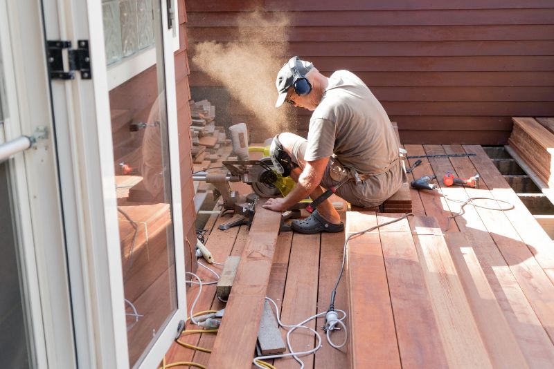 A Man Cutting Timber Decking Boards